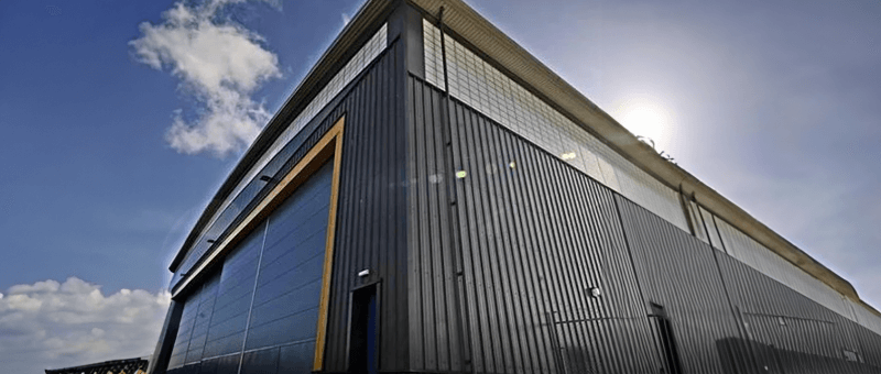 Exterior of a large hangar building on a secure site